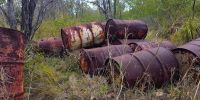 Nine 200L rusty drum barrels.
