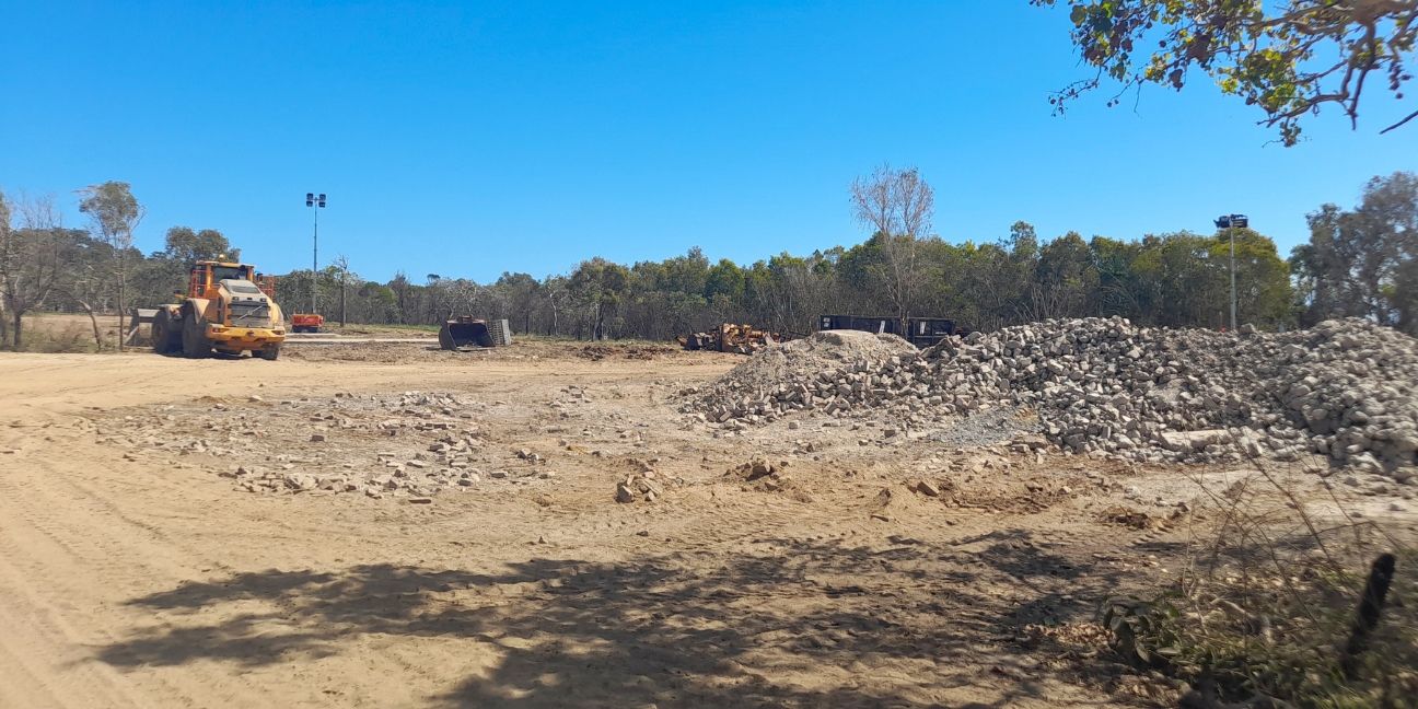 Piles of concrete and a yellow truck.