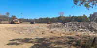 Piles of concrete and a yellow truck.