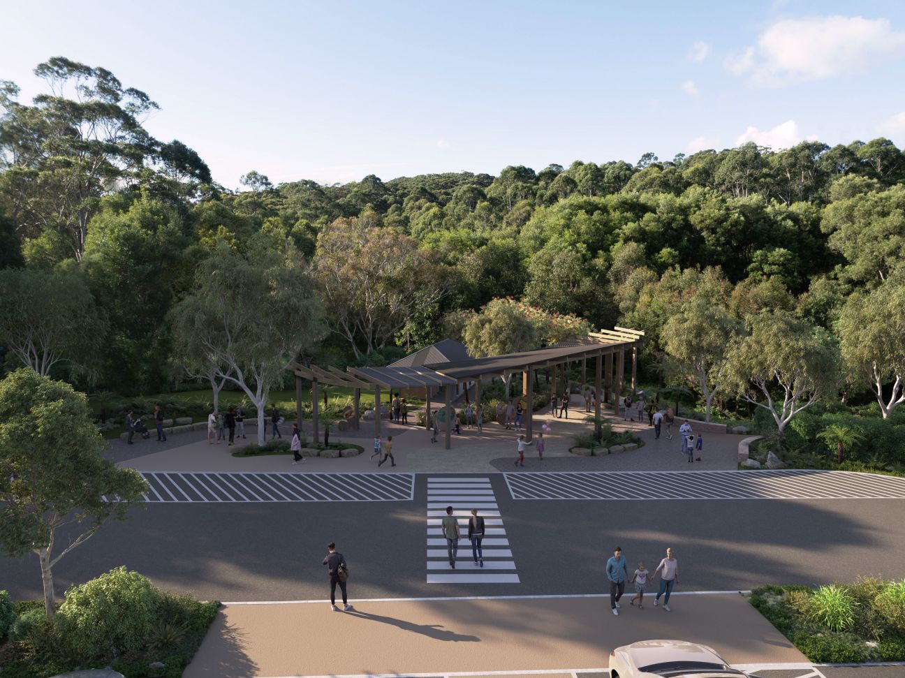 Photo of the Settlement picnic area as it will be when upgrades are complete, with visitors crossing a road to a large open-sided roofed visitor shelter and gathering area. The area is bounded by forest.