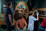 Photo of family interacts with educational displays about koala life cycle.
