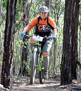 Mountain bike rider happily riding down a forest trail.
