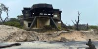 Concrete gun emplacement building perched on an eroding sand dune.