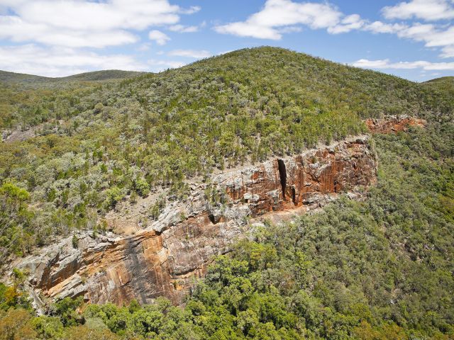 From Red Rock Gorge lookout, gaze across a dynamic deep gorge with high cliffs stained red by lichen.