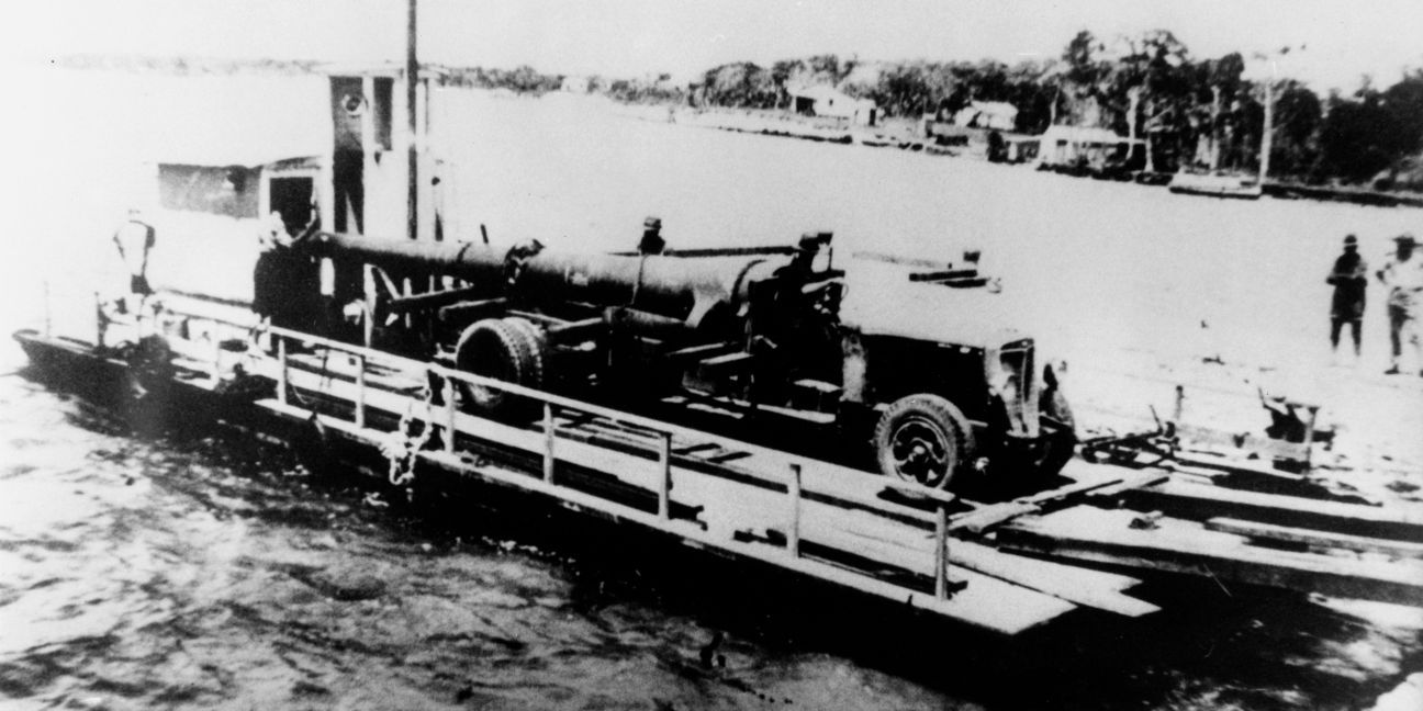 Black and white photo of a naval gun on the deck of a ferry.