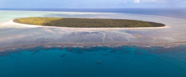 Aerial view of North West Island surrounded by blue sky and sea.