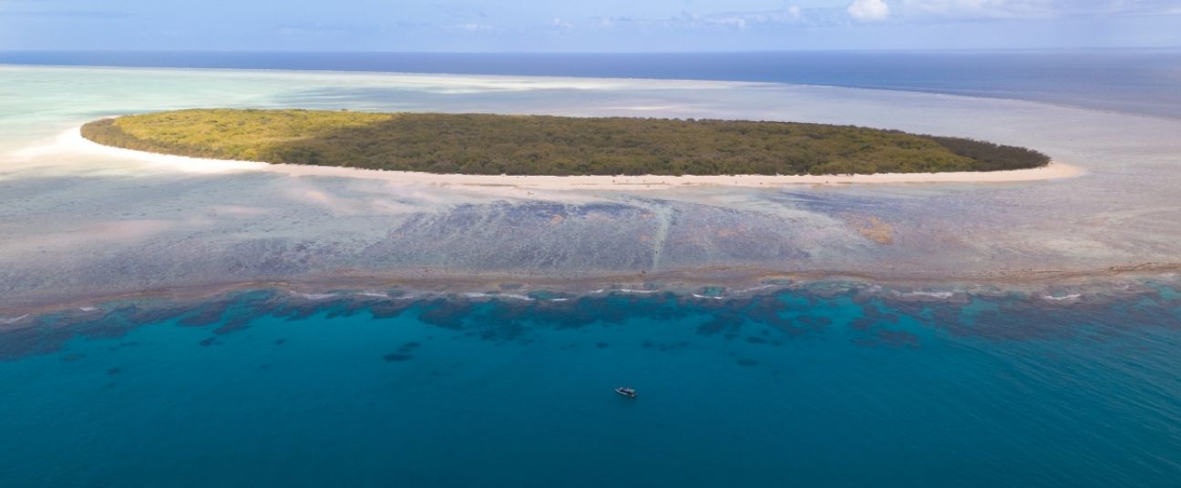 Aerial view of North West Island surrounded by blue sky and sea.