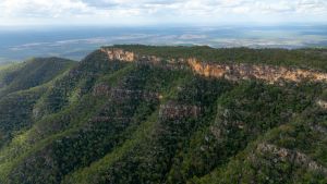 Blackdown Tableland National Park highlighting rugged cliffs with layered rock formations and dense vegetation, emphasizing the geological features.