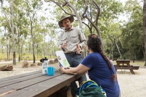 Photo of a park ranger talking to a member of the public who has downloaded the Atherton and Evelyn Tablelands parks journey guide.