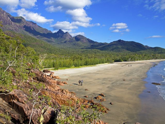 Walk in the shadow of the towering mountain range on the Thorsborne Trail.