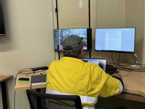 Photo of a Ranger planning for a planned burn at a desk in an office.