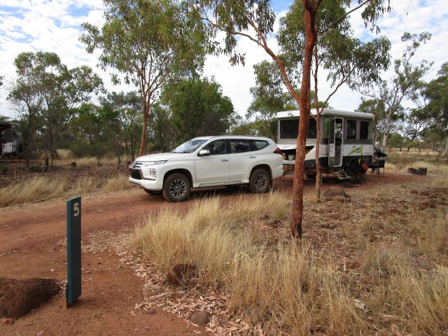 Photo of a white 4wd in front of a camper trailer.