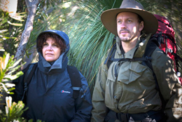 Photo of two walkers in wet weather gear and hats.