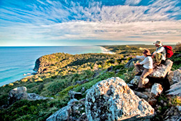 Photo of a group of walkers sitting back on rocks looking out over the horizon.