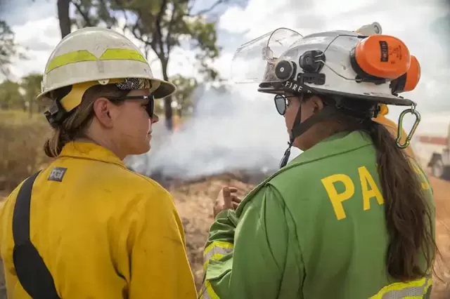 Two female first staff watching a planned burn