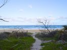 Photo of a sandy path meandering towards the beach
