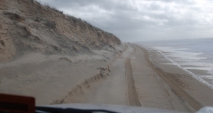 View from over the dashboard of driving on the beach.