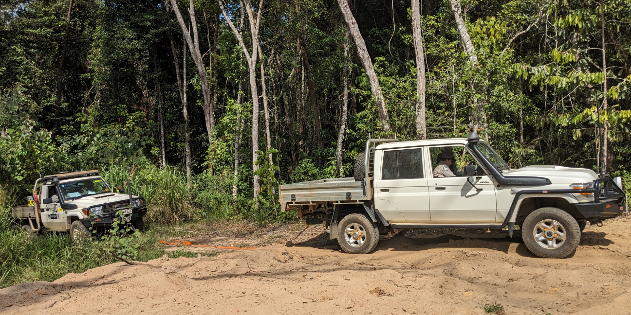 Four-wheel drive vehicle towing another four-wheel drive vehicle on a soft dirt road