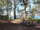 Photo of a shaded lake-front picnic table.